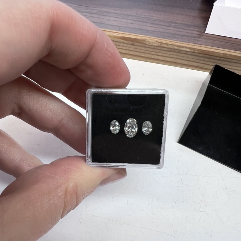 three oval diamonds in a case 